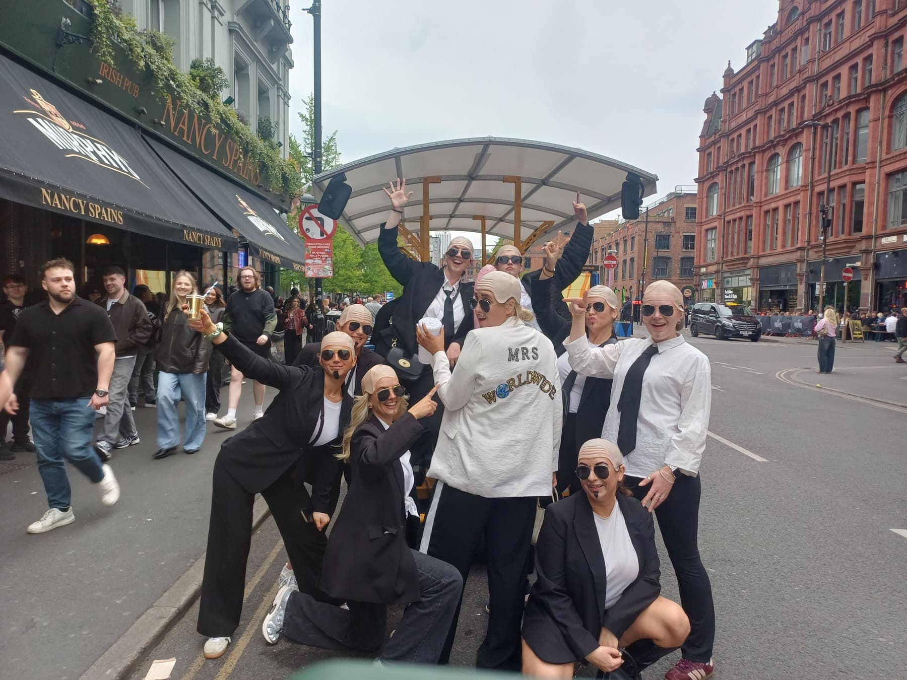 A large group in matching fancy dress beside the party bike in Manchester city centre