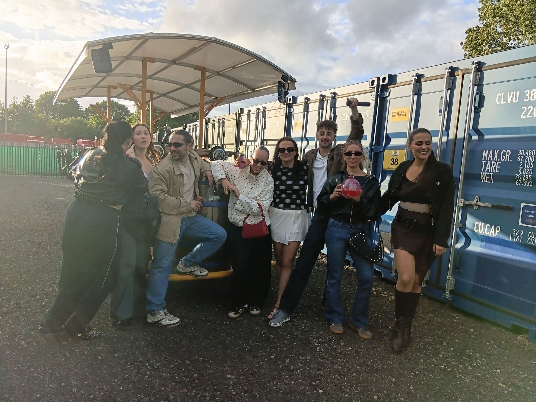 Students posing with drinks by the party bike in the evening sun