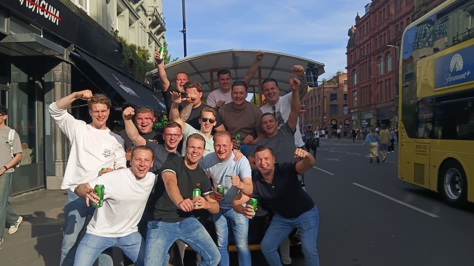 A student sports club celebrating on the PedalCity party bike on a Manchester street